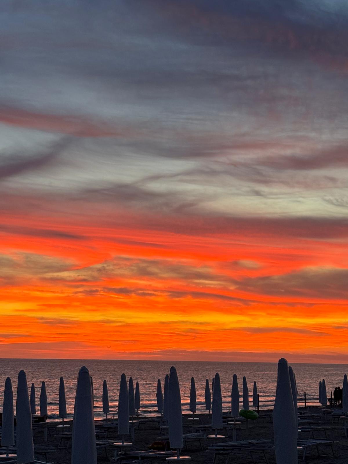 Tramonto sulla spiaggia con ombrelloni